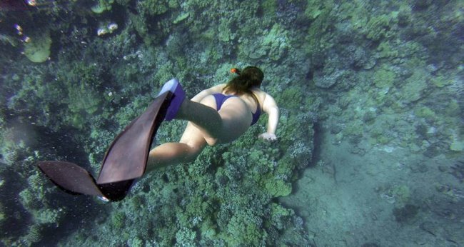 Devojka roni uz ronilačku opremu